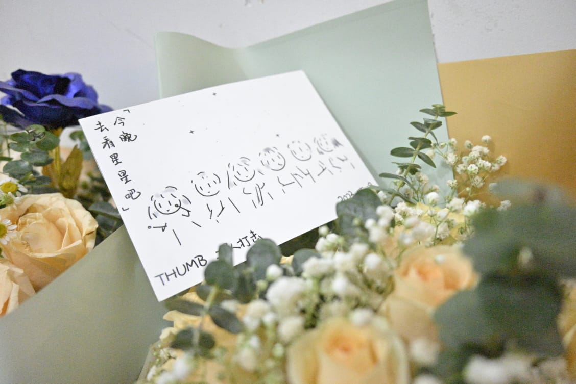 简笔画绘制的贺卡放在花束里。