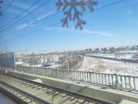 Landscape outside the train window, with patches of unmelted snow on the ground