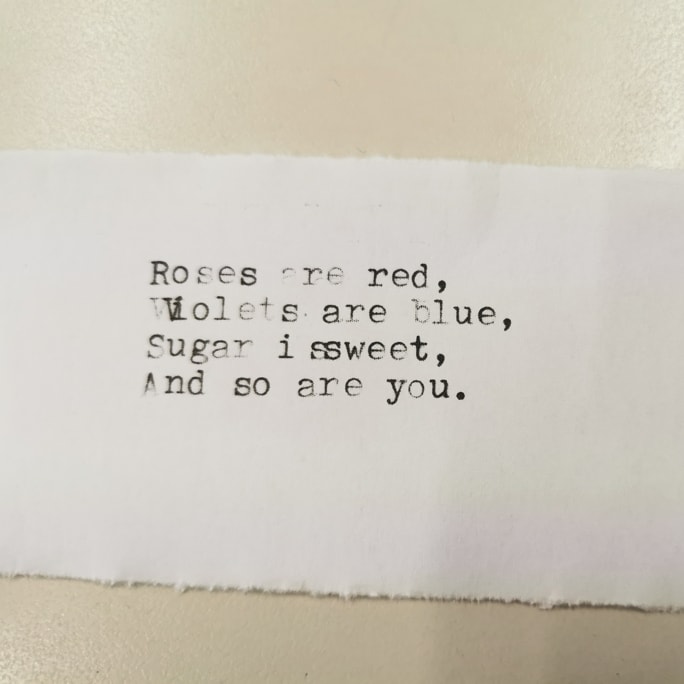 纸条，上面有打字机印出的几句诗歌：“Roses are red, violets are blue, sugar is sweet, and so are you”