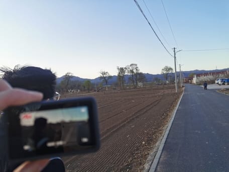 手持运动相机拍摄路上同行友人的情景。