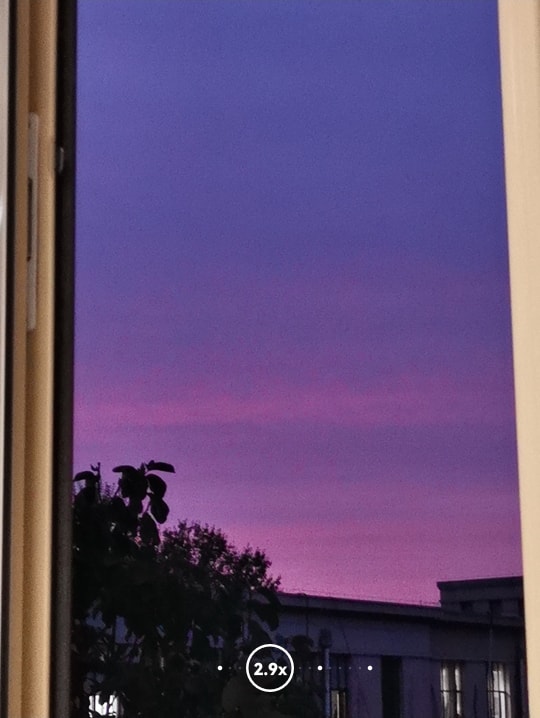 手机拍照界面上显示的窗外的紫色天空。