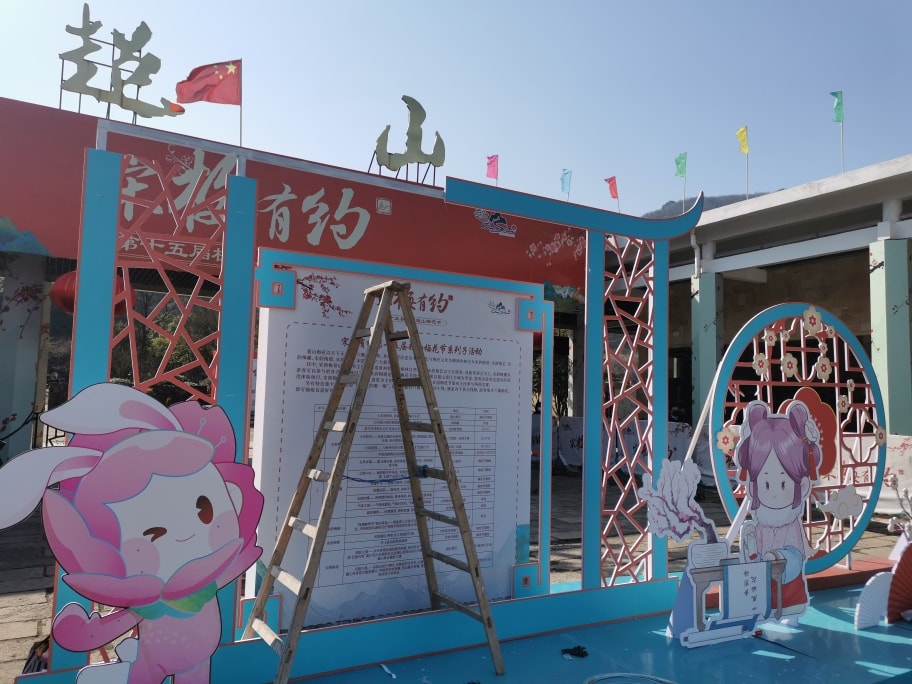 景区入口的公告板，以及超山梅花节的卡通女孩角色。
