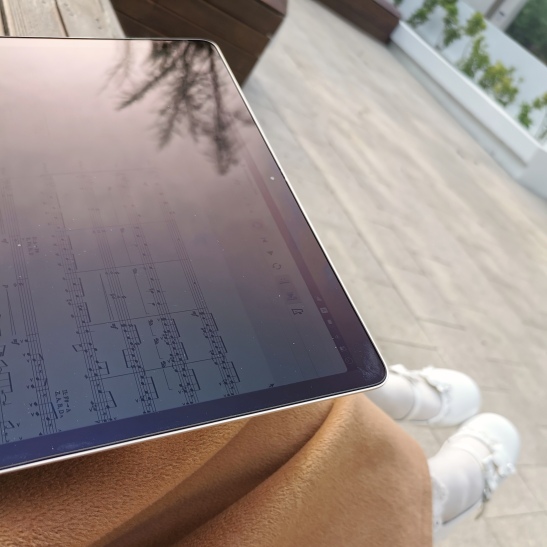 坐在长椅上用电脑编写乐谱的情景。