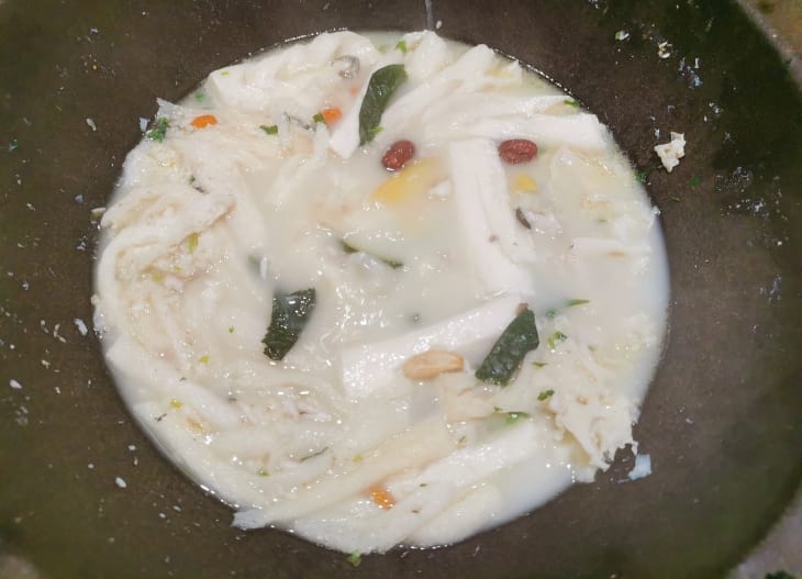 白色汤底中各种形状的白色食物，有的形似年糕