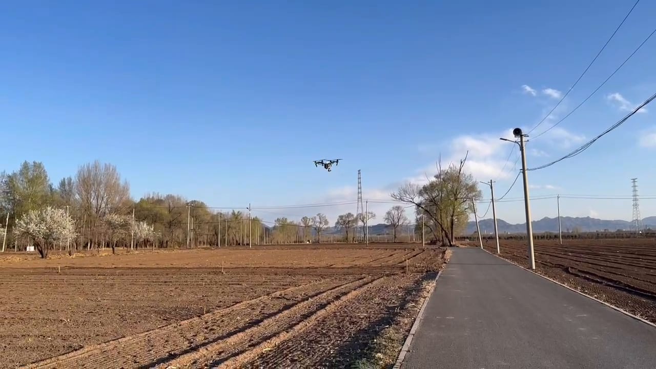 田野间低空飞行的无人机。
