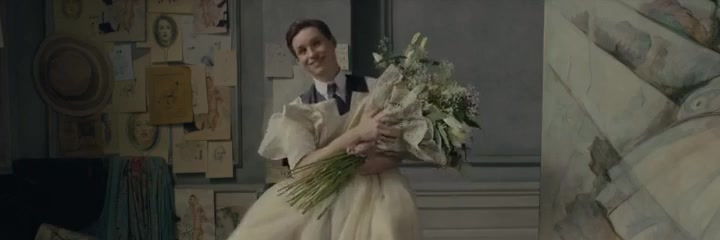 电影画面；主人公 Elbe 抱着花束与白色长裙坐在一幅油画画像旁。